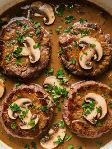 Savory Salisbury Steak Recipe with juicy beef patties simmered in a rich, homemade mushroom gravy, garnished with fresh parsley and sautéed mushrooms. A comforting and flavorful classic dish perfect for dinner.