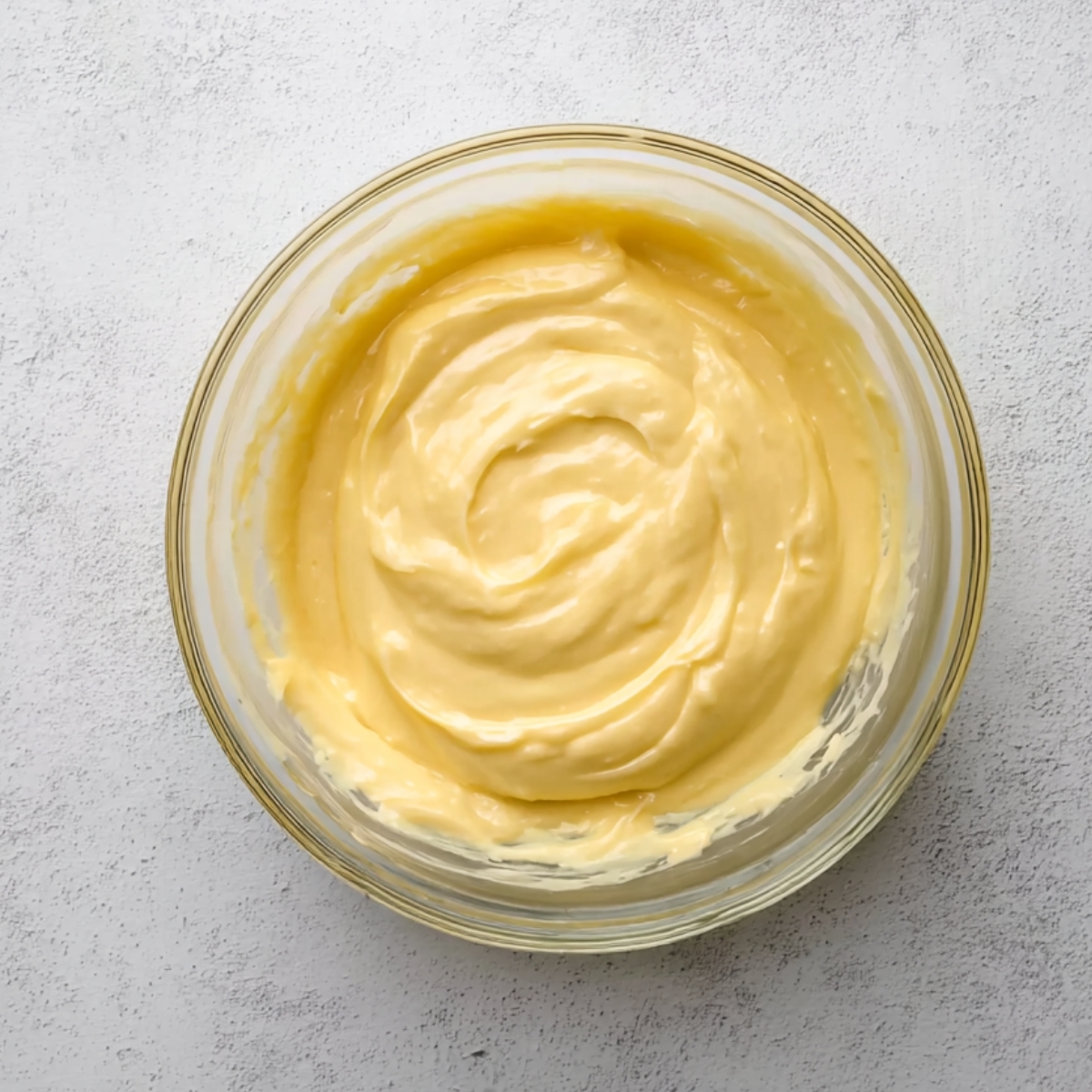 In a medium heat-proof bowl, whisk the sugar, cornstarch, and salt together until there are no lumps. Add the egg yolks and whisk hard for about a minute until the mixture turns pale yellow and smooth. Pour in the milk slowly, whisking the whole time so the yolks don't scramble. Transfer everything to a saucepan and cook over medium-low heat, whisking constantly. After about 5 minutes, it'll start to simmer and thicken into a pudding-like consistency. Let it bubble gently for 1 more minute while you keep stirring. Pull it off the heat, whisk in the vanilla, and strain it through a fine-mesh strainer into a clean bowl to catch any cooked bits.