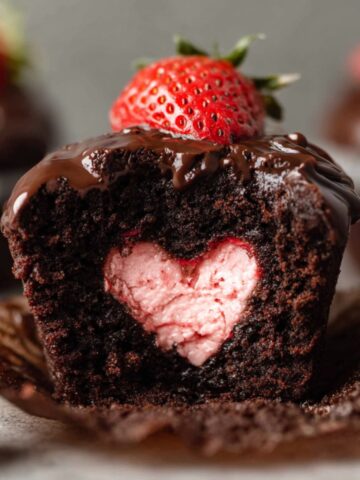 Chocolate Covered Strawberry Cupcakes with a heart-shaped strawberry filling, topped with ganache and a strawberry.