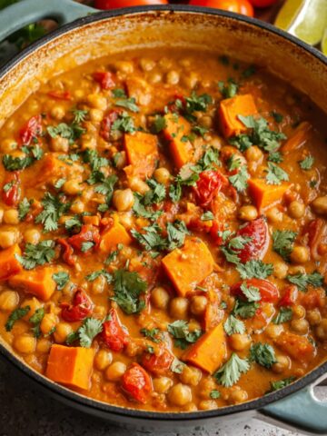 Sweet Potato Chickpea Curry with cilantro in a rustic pot.