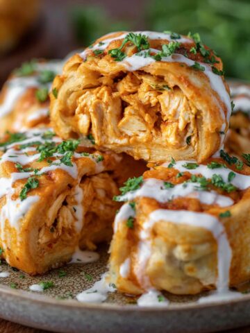 Buffalo Chicken Roll Ups drizzled with ranch and garnished with parsley.