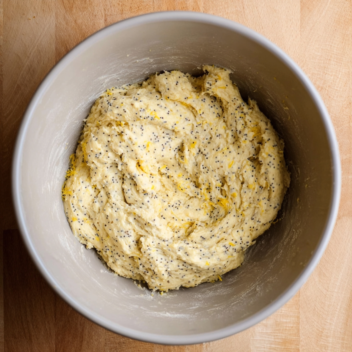 A close-up of the lemon poppy seed cookie dough in a mixing bowl before baking.
