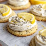 A batch of soft and fluffy Lemon Poppy Seed Cheesecake Cookies topped with lemon slices and poppy seeds.